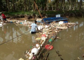 Warga mengangkat sampah di Muara Pancur, Sei Beduk, Batam. (Foto: arsip Akar Bhumi Indonesia)