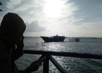 Warga menonton kapal penyelundup yang kandas di pantai Bale-Bale, Kecamatan Nongsa, Kota Batam, Kepulauan Riau. (Foto: Bintang Hasibuan)