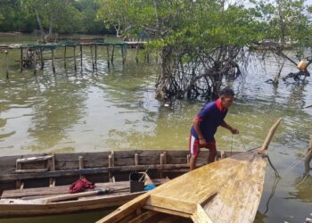 Iskandar (40) sedang bersiap untuk turun ke laut mencari sotong dan ikan. (Foto: Muhamad Ishlahuddin)