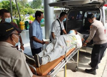 Briptu Rahmad Dani Saputra, membatu penumpang sakit di Pelabuhan Feri Dosmestik, Batu Ampar. (Foto: Muhamad Ishlahuddin)