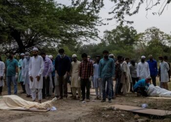 Warga Muslim India melakukan shalat jenazah korban Covid-19 sebelum dimakamkan di New Delhi (Foto: Reuters).