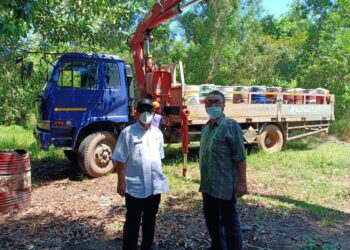 Kepala Seksi Pengelolaan Limbah B3 DLHK Kepri, Edison (kiri), memantau proses pengangkutan limbah sludge oil yang mencemari perairan Nongsa. (Foto: Arsip narasumber)