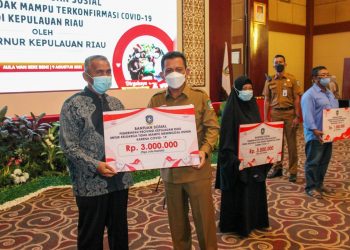 Gubernur Kepri, Ansar Ahmad memberikan bantuan sosial uang tunai kepada salah satu warga yang terdampak Covid-19 di Aula Wan Seri Beni, Dompak, Tanjungpinang, Senin, 9 Agustus 2021. (Foto: Humas Pemprov Kepri)