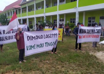 Warga membentangkan spanduk penolakan proyek pelebaran jalan oleh BP Batam. (Foto: SIR)