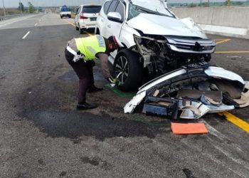 Petugas Kepolisian memeriksa mobil yang ditumpangi Vanessa Angel dan keluarga yang ringsek akibat kecelakaan di jalanTol Jombang, Jawa Timur.