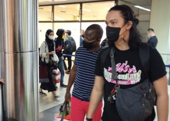 Pelaku WN Nigeria saat tiba di Batam, Kepulauan Riau, melalui Bandara Hang Nadim Batam dengan pengawalan petugas Kepolisian, Rabu, 1 Desember 2021. (Satreskrim Polresta Barelang)