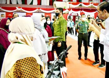 Presiden Jokowi menyerahkan hadiah seoeda kepada warga yang berhasil menjawab pertanyaan di acara pembagian sertipikat tanah untuk rakyat di Kota Tarakan, Kaltara, Selasa,  21 Desember 2021. (Foto: setneg.go.id)
