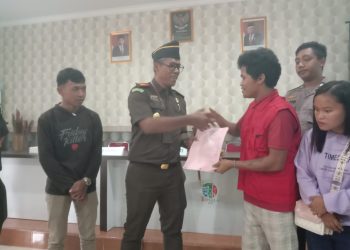 Kepala Kejari Bintan I Wayan Eka Widdyara, menyalami Julianus (rompi merah) usai memberikan Restorative Justice (RJ) yang berlangsung di Balai Desa Toapaya Selatan, Kecamatan Toapaya, Kabupaten Bintan, Kamis (26/01/2023). (Foto: HMS/ Yulita Dani).