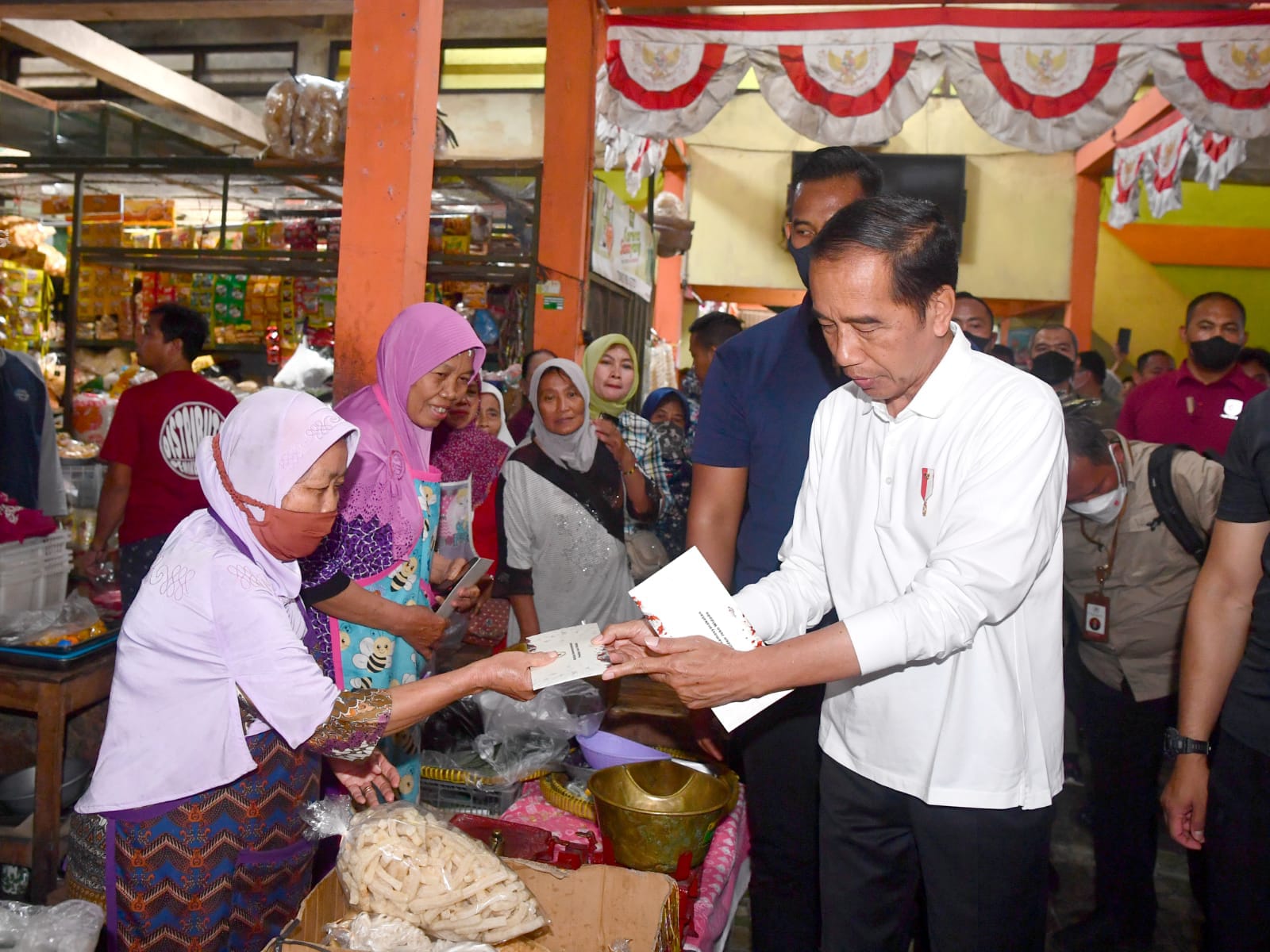 Presiden Joko Widodo memberikan bantuan dana tunai ke sejumlah pedagang saat berkunjung ke Pasar Sentul, Yogyakarta, Minggu (08/01/2023). (Foto: Ist/ setneg.go.id).