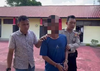 TR (tengah) saat digiring ke Polsek Bintan Utara untuk dilakukan penahanan atas kasus pencurian. (Foto: HMS/ Yulita Dani).