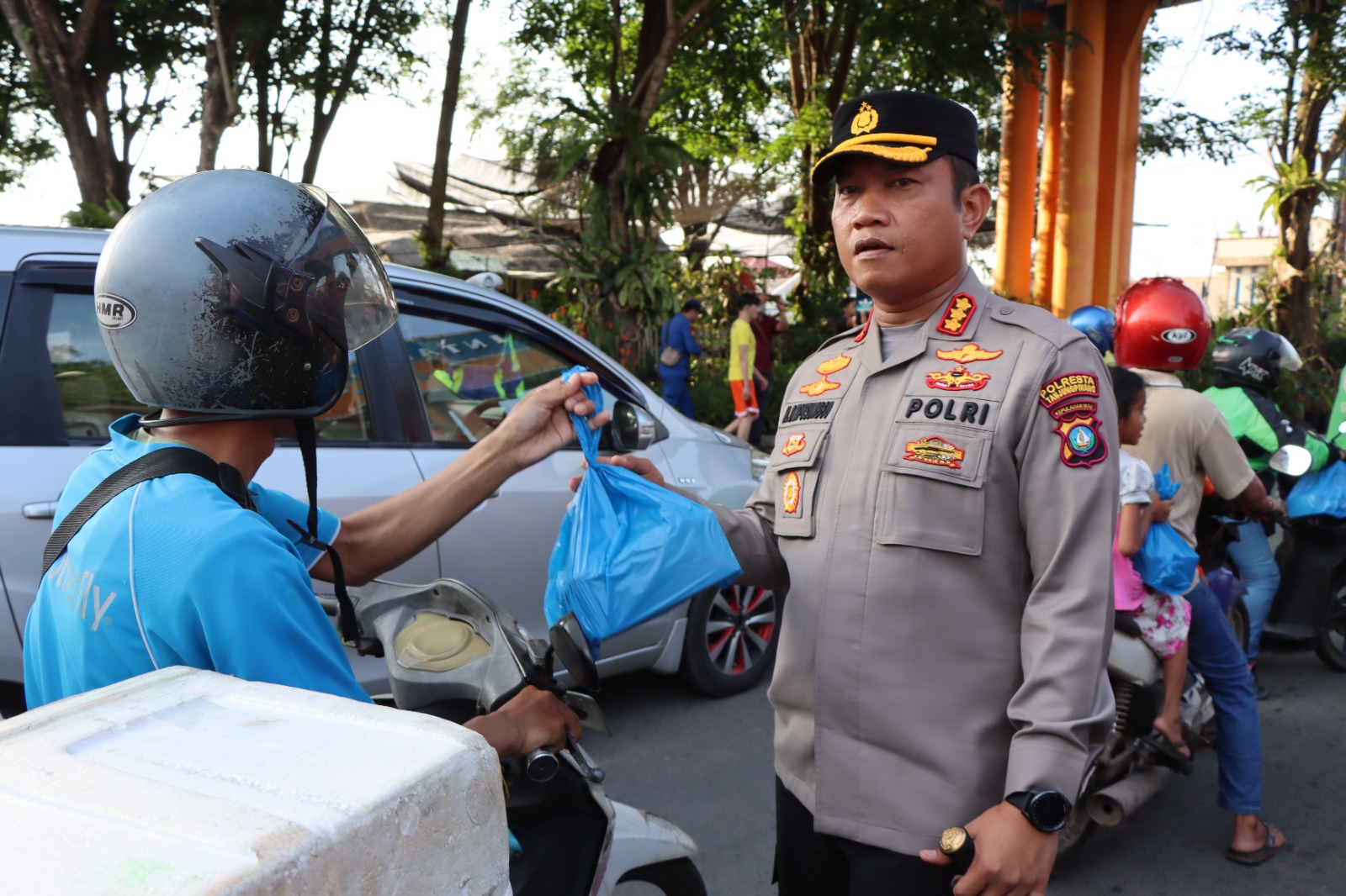 Kapolresta Tanjungpinang Kombes Pol H Ompusunggu, saat membagikan takjil dan makanan siap saji kepada salah satu pengendara yang melewati jalan Bincen KM 9, Tanjungpinang, Selasa (11/4/2023) sore. (Foto: HMS/ Yulita Dani).