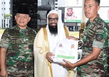 Seorang Perwira TNI AD secara simbolis menerima bingkisan sumbangan Raja Salman bin Abdulazis yang diserahkan Atase Pertahanan, Agama dan Pendidikan Kerajaan Arab Saudi, Ahmed Essa L Alhazmi (tengah), disaksikan Kasad Jenderal TNI Dudung Abdurachman. (Foto: Ist/ Puspenad).