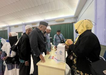Petugas membagikan 5 liter air zamzam untuk jemaah haji debarkasi Batam saat tiba di Asrama Haji Batam. (Foto: Irvan Fanani)