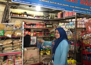 Pedagang di Pasar Botania 2, Mimi saat menunjukkan QR Code toko sembako miliknya (Foto: Irvan Fanani)