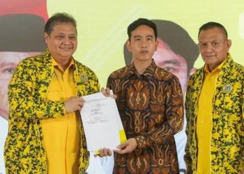 Gibran Rakabuming Raka (tengah) menerima surat keputusan Rapimnas Partai Golkar dari Ketua Umum Airlangga Harrarto (kiri). Rapimnas memutuskan Partai Golkar mengusung dan mendukung Gibran cawapres dari Prabowo Subianto. (Foto: Ist./dok. Partai Golkar).