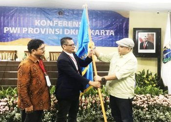 Ketua Bidang Organisasi PWI Pusat, H. Zulmansyah Sekedang (kanan) meyerahkan bendera kepada Ketua PWI Jaya terpilih Kesit Budi Handoyo dalam Konperensi PWI Provinsi DKI Jakarta, Kamis, 25 April 2024 di Balaikota Jl.Merdeka Selatan. Ikut mendampingi Ketua Dewan Kehormatan terpilih Theo Yusuf (kiri). (Foto: HMS/A.Ristanto).