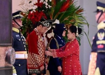 Ibu Negara, Iriana Joko Widodo membantu merapikan busana adat yang dikenakan Presiden Joko Widodo, sebelum memimpin upacara penurunan bendera di Ibu Kota Nusantara (IKN), Sabtu, 17 Agustus 2024. (Foto: Ist./presidenri.go.id).