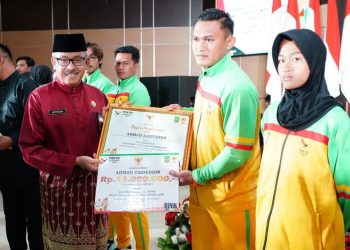 Sekda Batam, Jefridin memberikan bonus uang secara simbolik pada pelatih PON XXI Aceh-Sumut yang berprestasi. (Foto: Diskominfo).