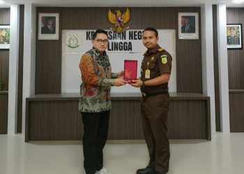 Zamroni selaku Komisioner Bawaslu Lingga Kordiv Penanganan Pelanggaran memberikan penghargaan kepada Kejaksaan Negeri Lingga yang diwakili oleh Kasi Datun ANDREANSYAH PAHLEVI, S.H. (Foto: Paino/Ist).