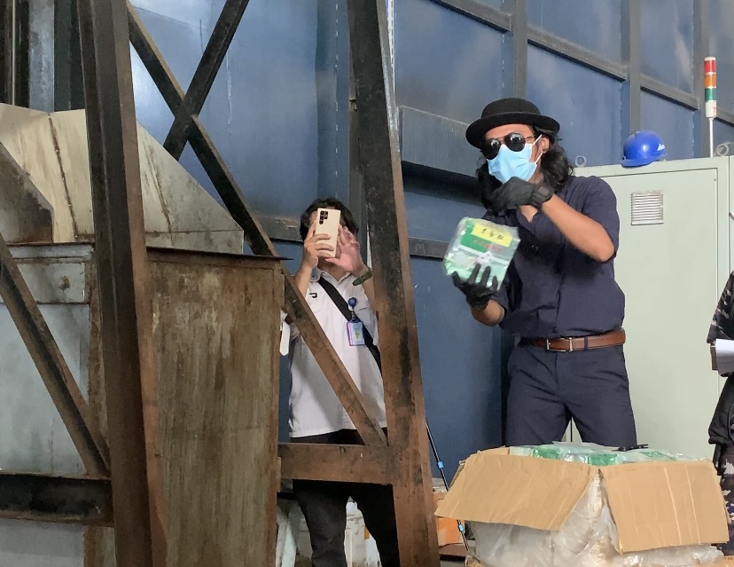 Influencer Batam, Okto Siagian, saat memasukkan barang bukti sabu ke mesin pemusnah narkotika di PT Desa Air Cargo Batam, Nongsa, Kamis, 12 Juni 2025.