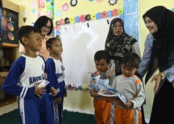 Pengurus Cabang Lanud RSA, Ny. Dewi I Ketut Adiyasa, saat membagikan buku dan alat tulis kepada pelajar TK Desa Pengadah. (Foto: Pen Lanud RSA /Ketua Yasarini).