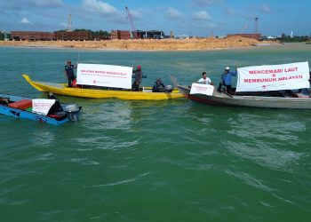 Peserta aksi damai ‘Nelayan Batam Menggugat’ membentangkan
spanduk penolakan aktivitas reklamasi yang mencemari perairan Nongsa, Kota Batam,
Rabu (24/12). Mereka mendesak mendesak Kementerian Lingkungan Hidup untuk
mengaudit pencemaran laut, menghentikan aktivitas yang berdampak, mendesak
perusahaan melakukan pemulihan ekosistem pesisir, serta memastikan perlindungan
ekonomi dan hak hidup nelayan terdampak. (Foto: Akar Bhumi Indonesia).