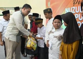 Ketua Umum PPK Kosgoro 1957 Dave Akbarshah Fikarno Laksono menyerahkan paket bantuan pada anak yatim di sela peringatan Nuzulul Qur'an di Masjid Raya Al Hurriyyah, Puri Kembangan, Jakarta Barat, Sabtu, 14 Maret 2026. (Foto: Ist./Kosgoro 1957).