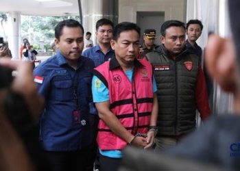 Ketua Ombudsman RI, Hery Susanto sebagai tersangka. Hery keluar dari Gedung Pidsus Kejagung menggunakan rompi tahanan pink. (Foto: Ist./ cnbcindonesia.com).
