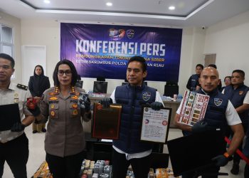 Pejabat Polda Kepri saat menunjukan barang bukti praktik perjudian online internasional di Kota Batam (Dok: Polda Kepri)